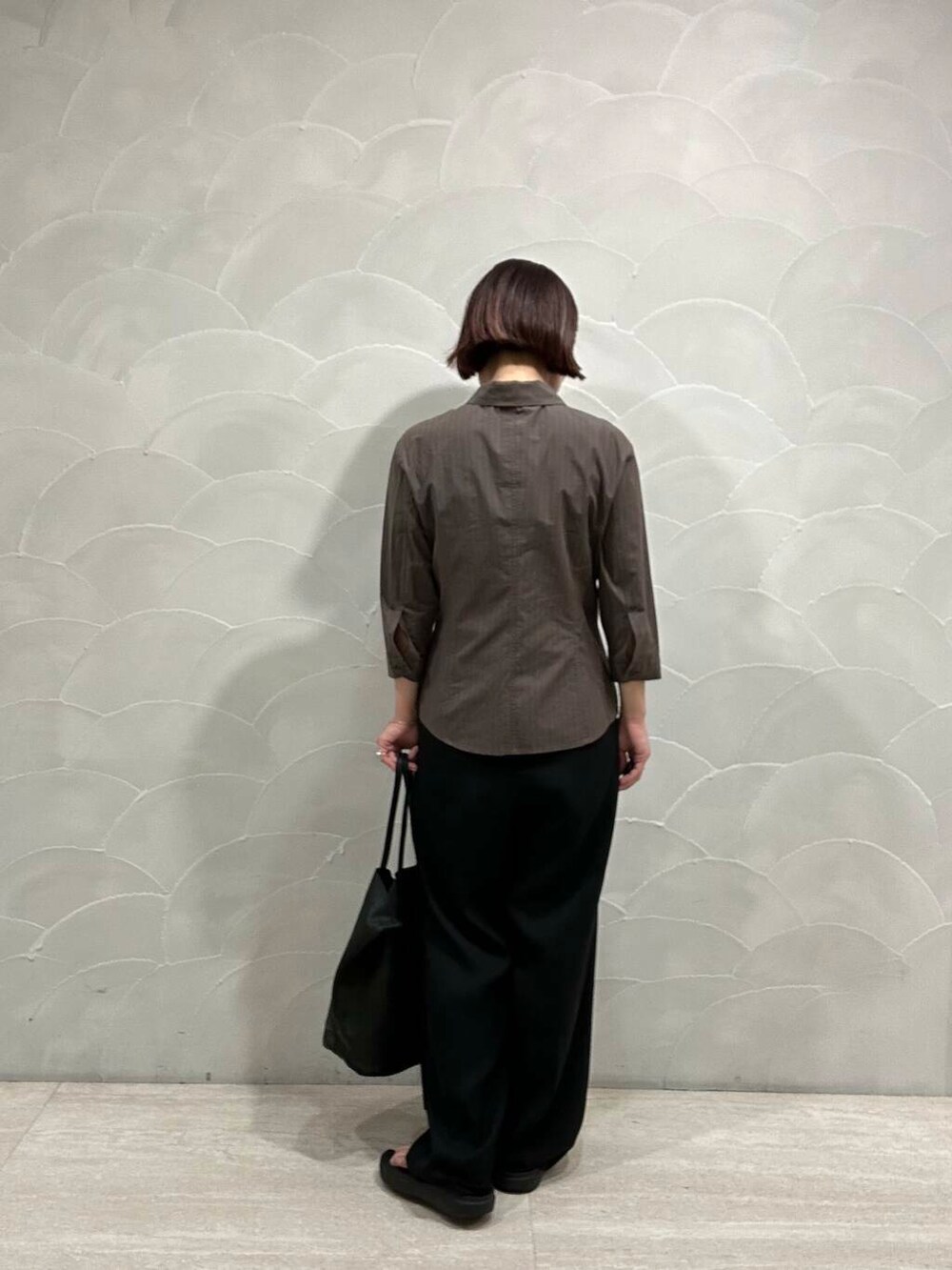 ブラック系のサンダル、ブラック系のトートバッグを着用したレディースの夏コーディネートの2枚目の写真