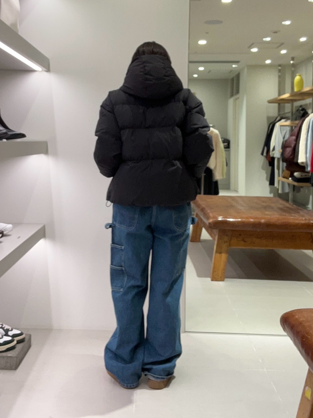 ブルー系のデニムパンツ、ブラック系のダウンジャケット/コート、イエロー系のその他シューズを着用したレディースの秋コーディネートの2枚目の写真