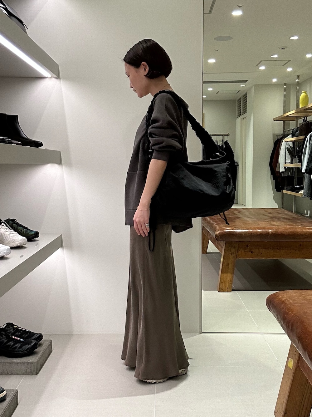 グレー系のカーディガン/ボレロ、ブラウン系のスカート、ブラック系のショルダーバッグを着用したレディースの秋コーディネートの2枚目の写真