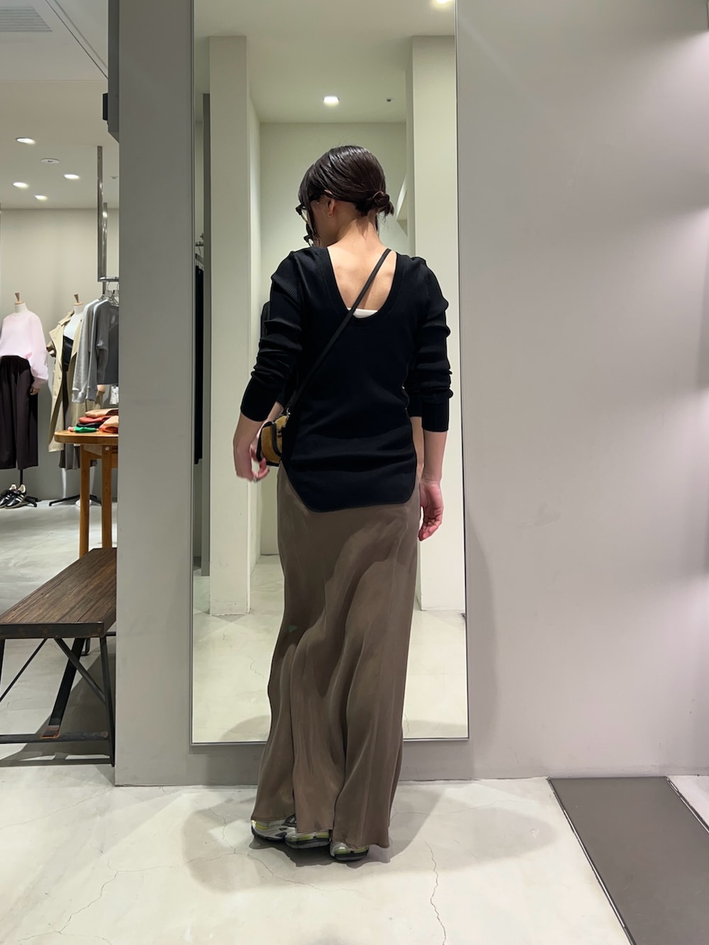 ブラック系のTシャツ/カットソー、ブラウン系のスカート、シルバー系のスニーカーを着用したレディースの春コーディネートの2枚目の写真