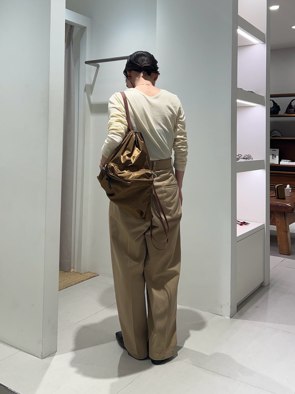 ベージュ系のその他パンツ、イエロー系のTシャツ/カットソー、ブラウン系のバックパック/リュックを着用したレディースの冬コーディネートの2枚目の写真