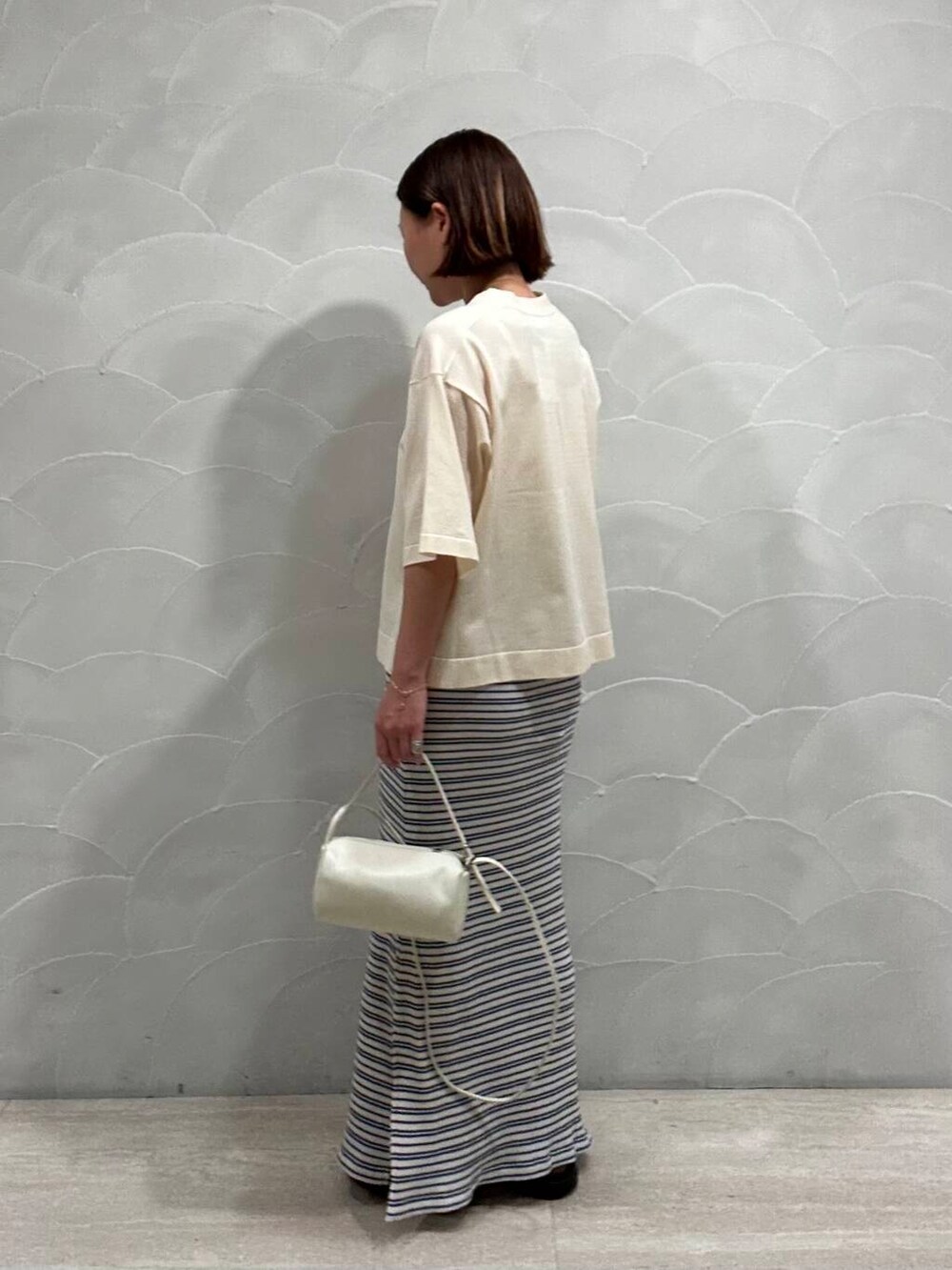 その他のスカート、ホワイト系のショルダーバッグ、ブラック系のサンダルを着用したレディースの夏コーディネートの2枚目の写真