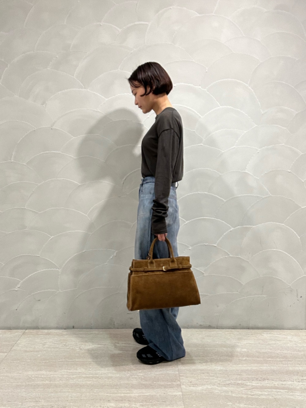 ブルー系のその他パンツ、ブラウン系のトートバッグ、グレー系のTシャツ/カットソーを着用したレディースの秋コーディネートの2枚目の写真