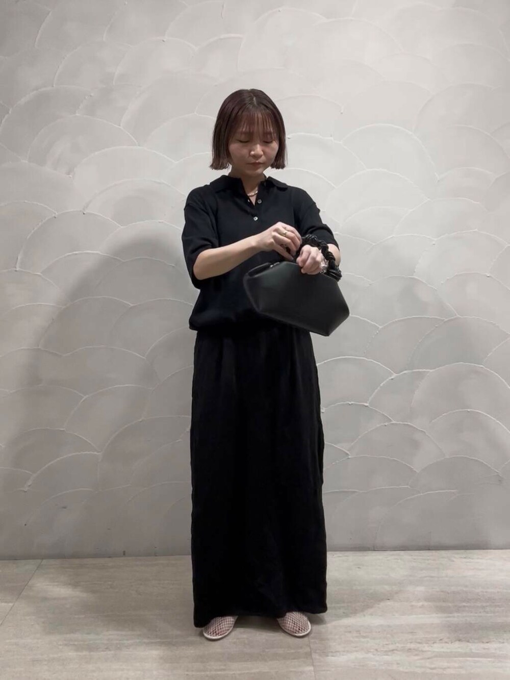 ホワイト系のパンプス、ブラック系のスカート、ブラック系のニット/セーターを着用したレディースの夏コーディネートの2枚目の写真