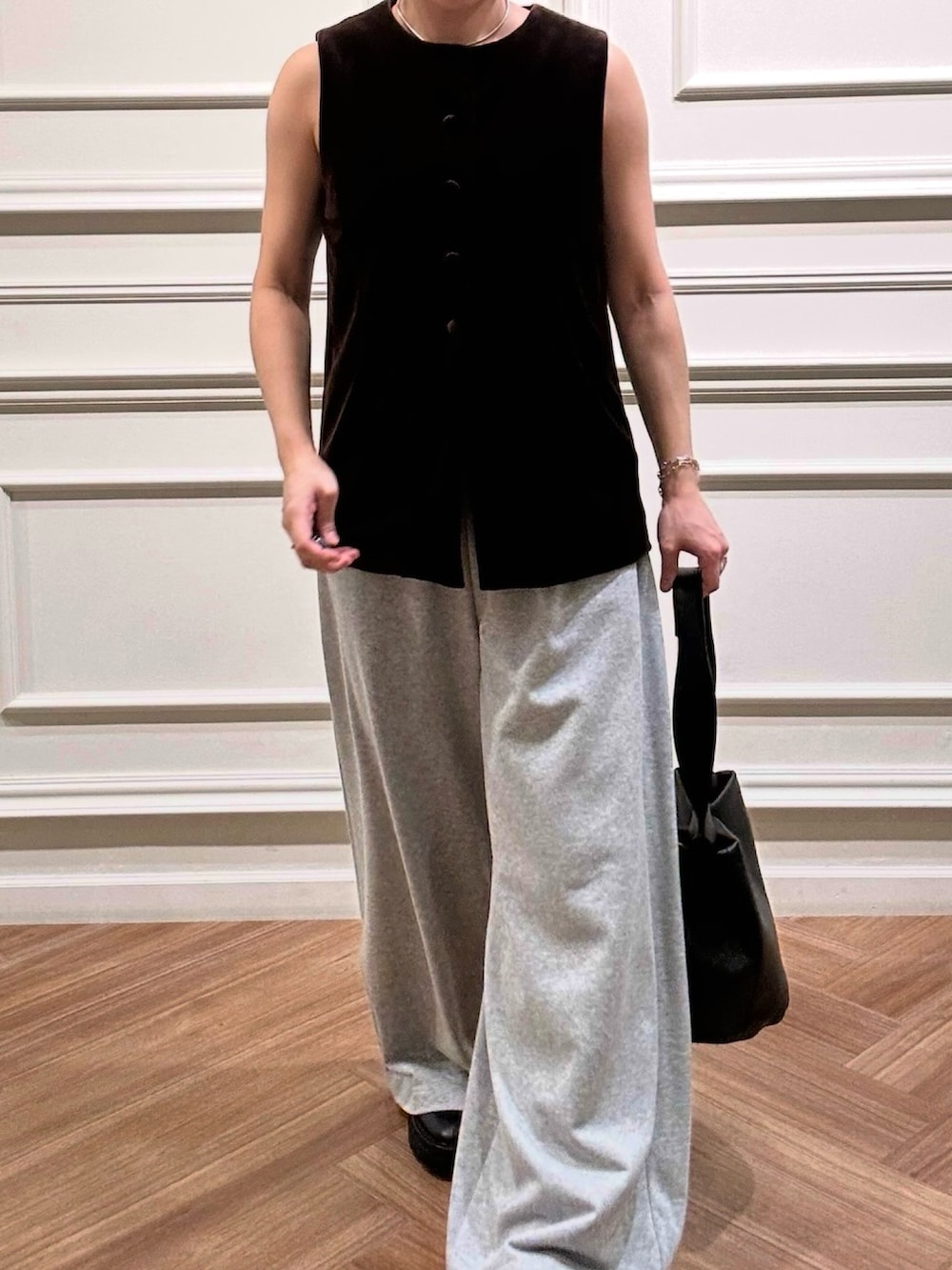グレー系のその他パンツ、ブラック系のハンドバッグ、ブラウン系のベストを着用したレディースの秋コーディネートの2枚目の写真