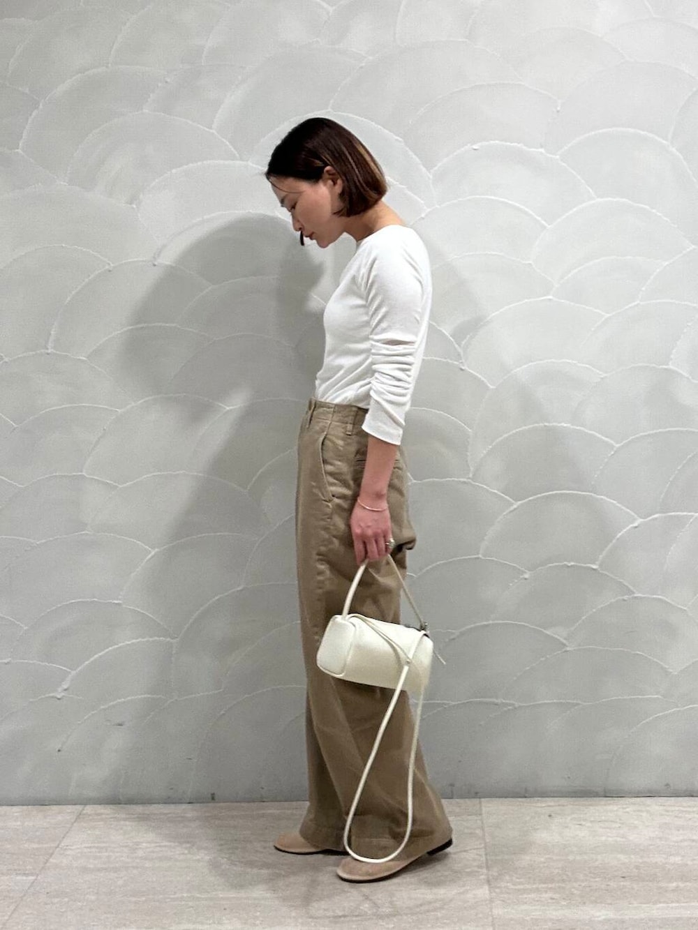 ホワイト系のショルダーバッグ、ベージュ系のバレエシューズ、ホワイト系のTシャツ/カットソーを着用したレディースの夏コーディネートの2枚目の写真