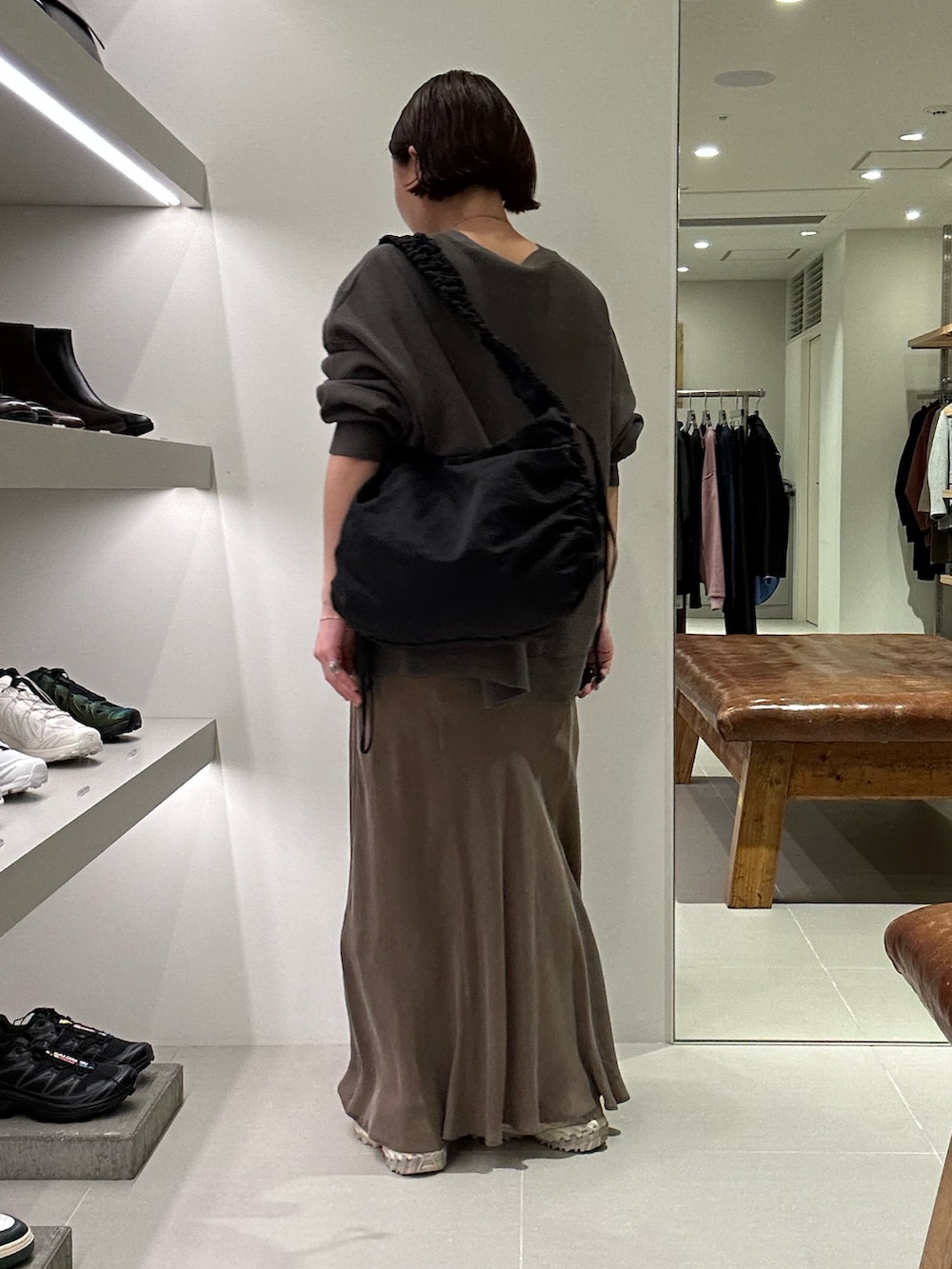 グレー系のカーディガン/ボレロ、ブラウン系のスカート、ブラック系のショルダーバッグを着用したレディースの秋コーディネートの3枚目の写真