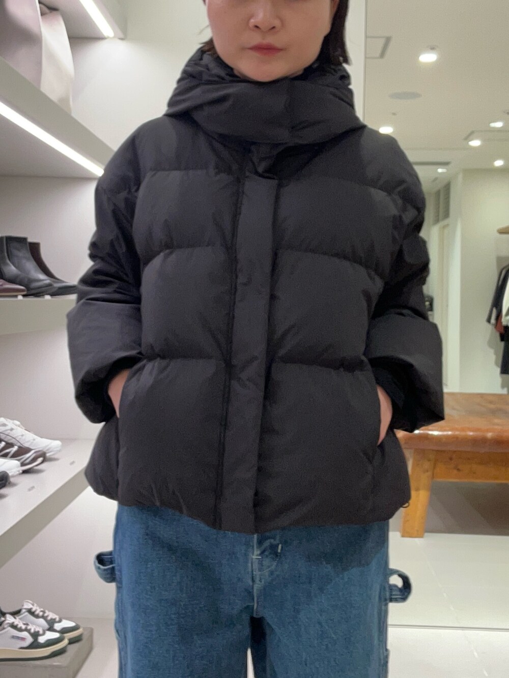 ブルー系のデニムパンツ、ブラック系のダウンジャケット/コート、イエロー系のその他シューズを着用したレディースの秋コーディネートの3枚目の写真