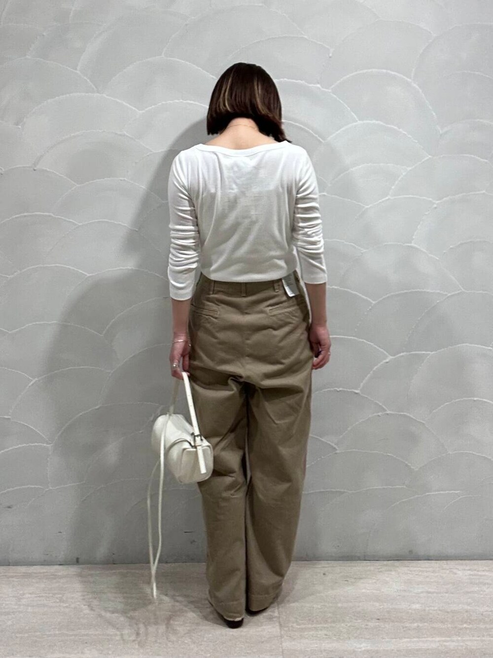 ホワイト系のショルダーバッグ、ベージュ系のバレエシューズ、ホワイト系のTシャツ/カットソーを着用したレディースの夏コーディネートの3枚目の写真