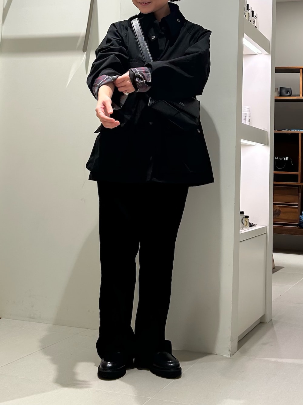 ブラック系のその他アウター、ブラック系のその他パンツ、ブルー系のハンドバッグを着用したレディースの秋コーディネートの2枚目の写真