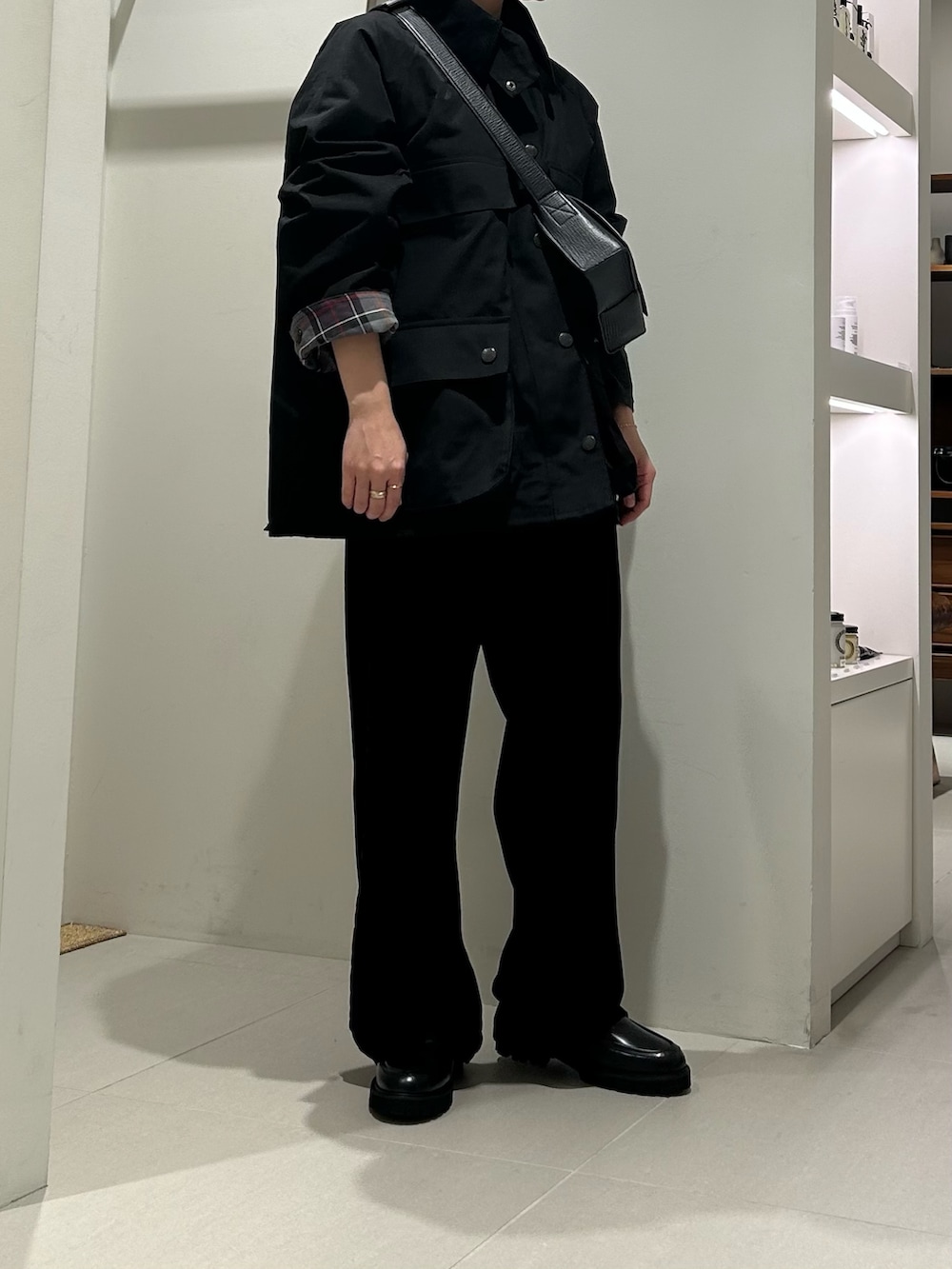 ブラック系のその他アウター、ブラック系のその他パンツ、ブルー系のハンドバッグを着用したレディースの秋コーディネートの3枚目の写真