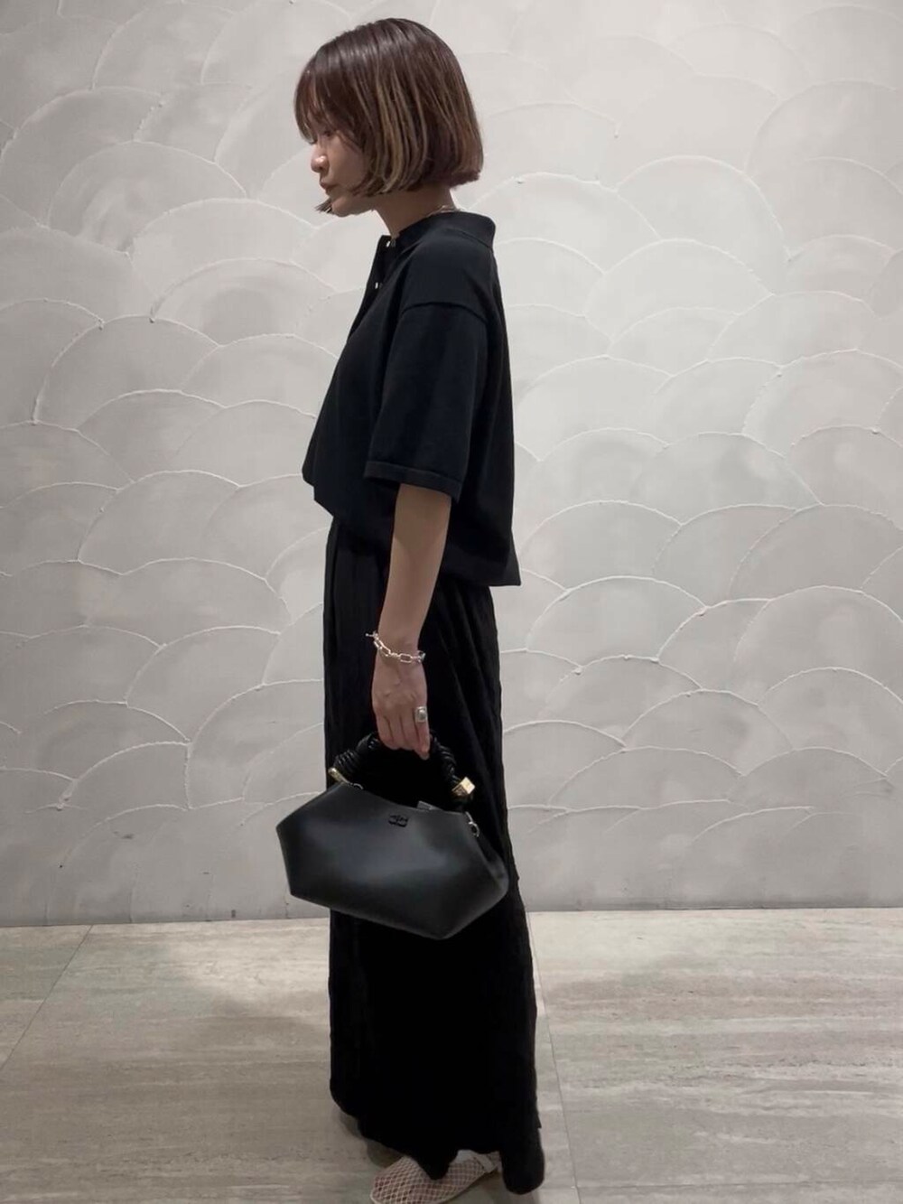 ホワイト系のパンプス、ブラック系のスカート、ブラック系のニット/セーターを着用したレディースの夏コーディネートの3枚目の写真