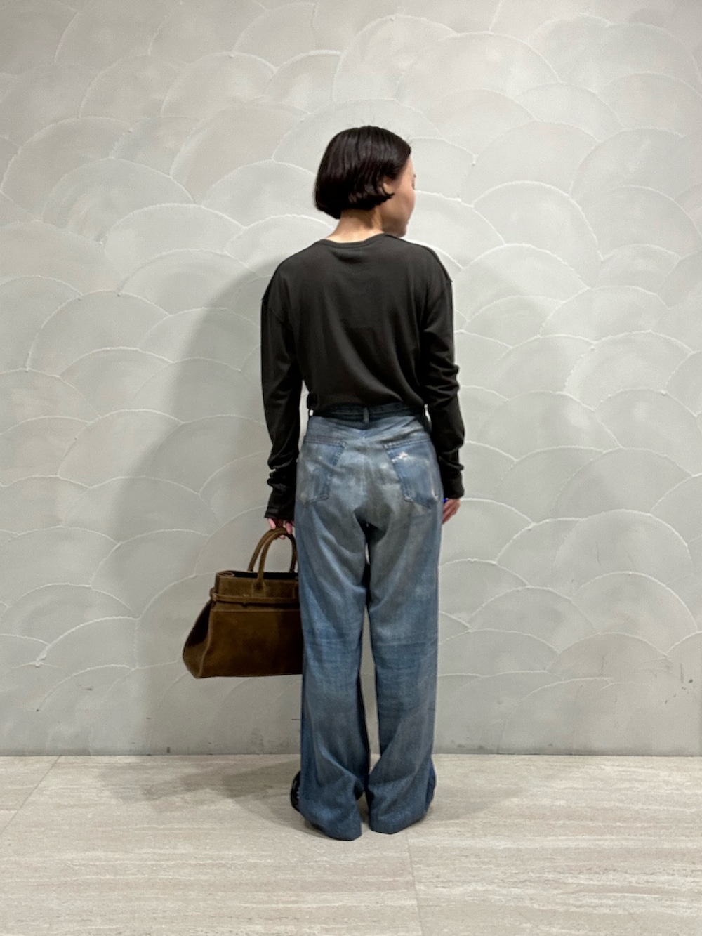 ブルー系のその他パンツ、ブラウン系のトートバッグ、グレー系のTシャツ/カットソーを着用したレディースの秋コーディネートの3枚目の写真