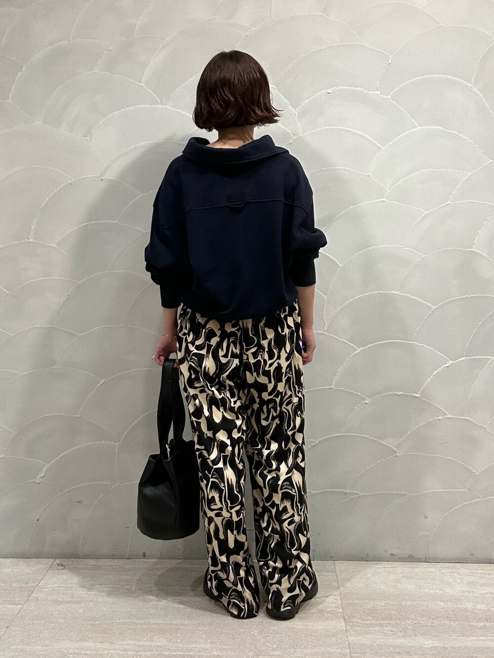 ブラック系のその他パンツ、ブラック系のハンドバッグ、ブラック系のスニーカーを着用したレディースの秋コーディネートの2枚目の写真