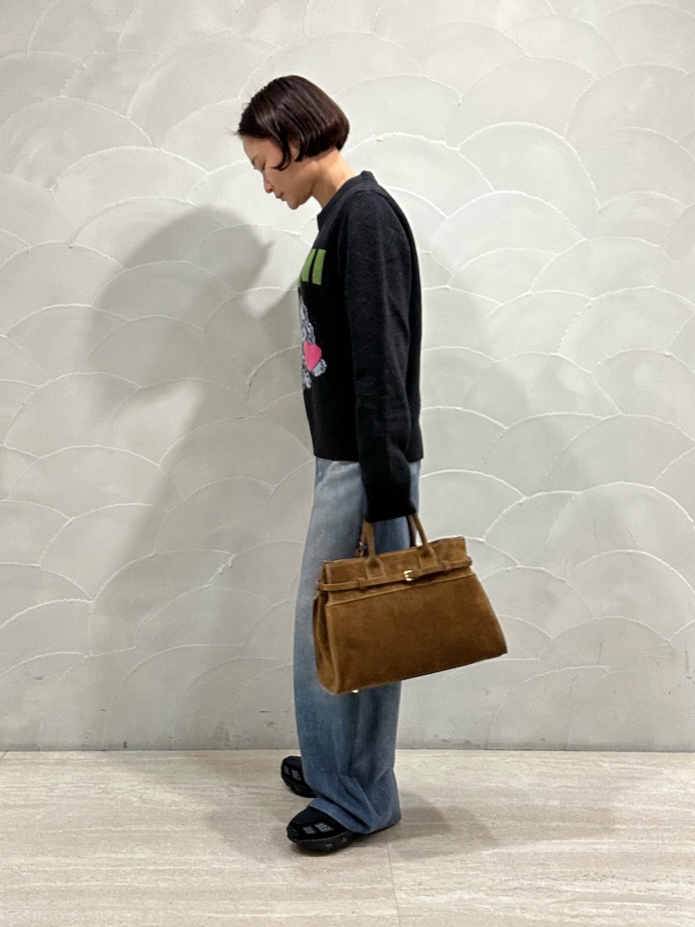 グレー系のニット/セーター、ブラウン系のトートバッグ、ブルー系のその他パンツを着用したレディースの秋コーディネートの2枚目の写真