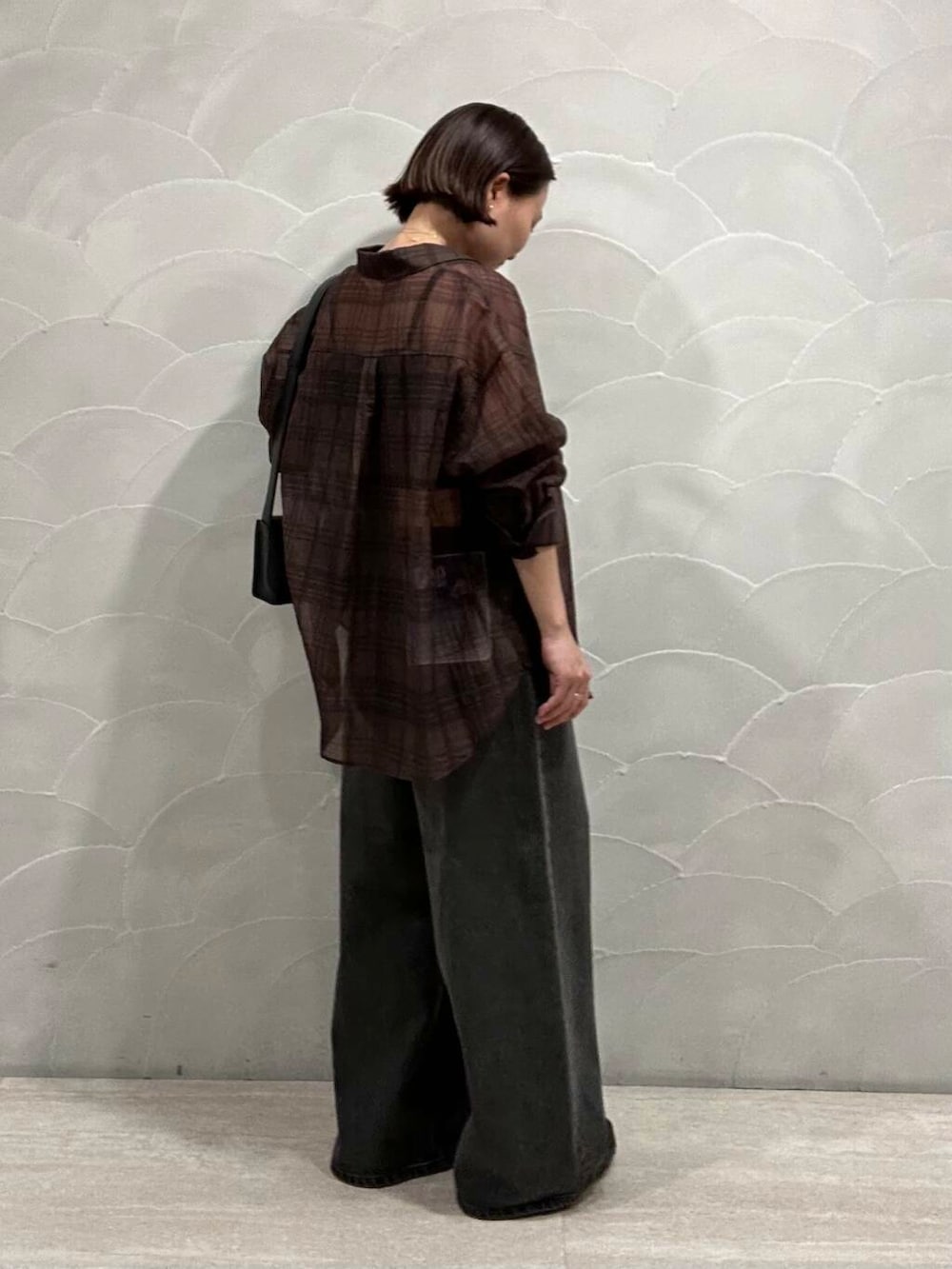 ブラック系のデニムパンツ、ブラウン系のシャツ/ブラウス、ブルー系のハンドバッグを着用したレディースの夏コーディネートの2枚目の写真