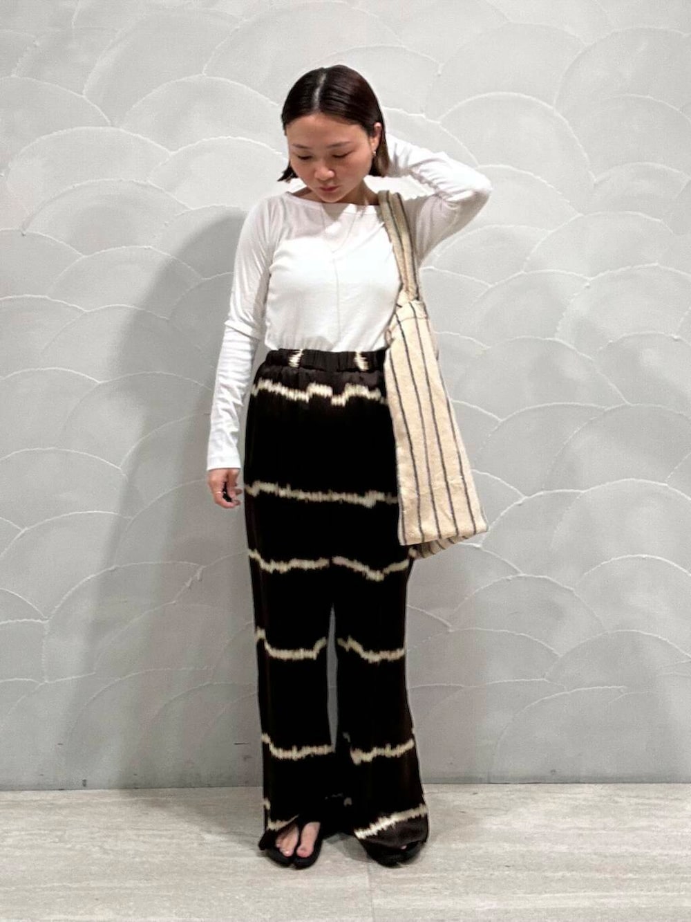 ブラウン系のその他パンツ、ブラック系のサンダル、ホワイト系のTシャツ/カットソーを着用したレディースの夏コーディネートの2枚目の写真