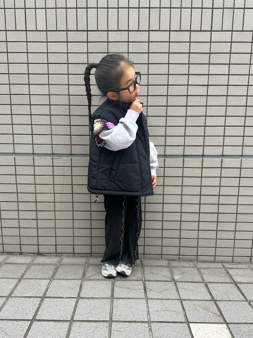 グレー系のスウェット、ブラック系のダウンベスト、ブラック系のその他パンツを着用したキッズの冬コーディネートの2枚目の写真