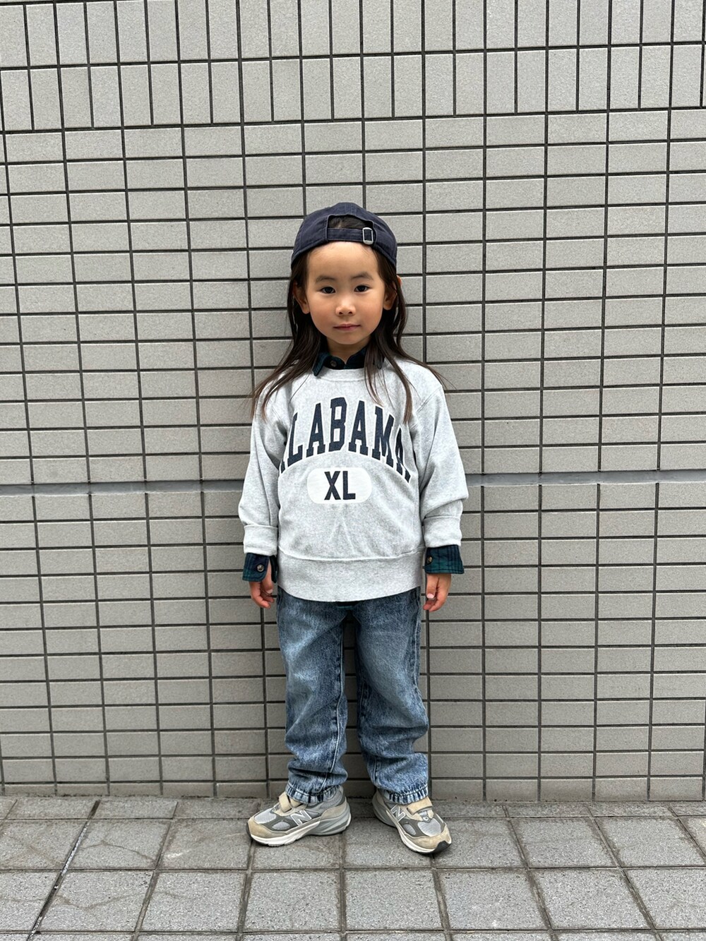 グレー系のスウェット、グレー系のスニーカー、ブルー系のデニムパンツを着用したキッズの冬コーディネートの3枚目の写真