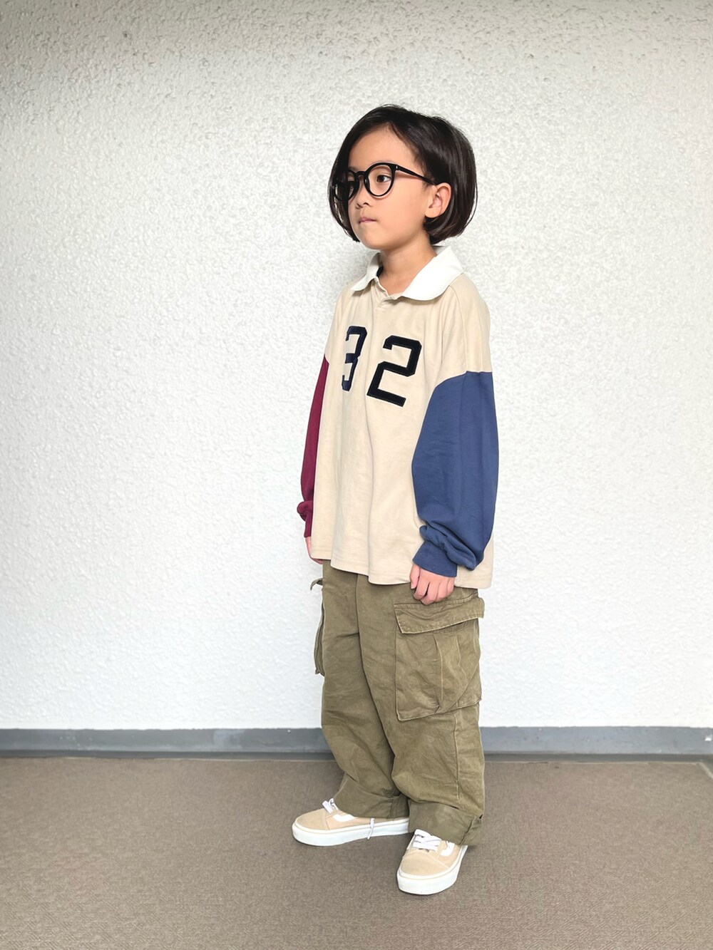 グリーン系のカーゴパンツ、ベージュ系のスニーカー、その他のポロシャツを着用したキッズの秋コーディネートの2枚目の写真