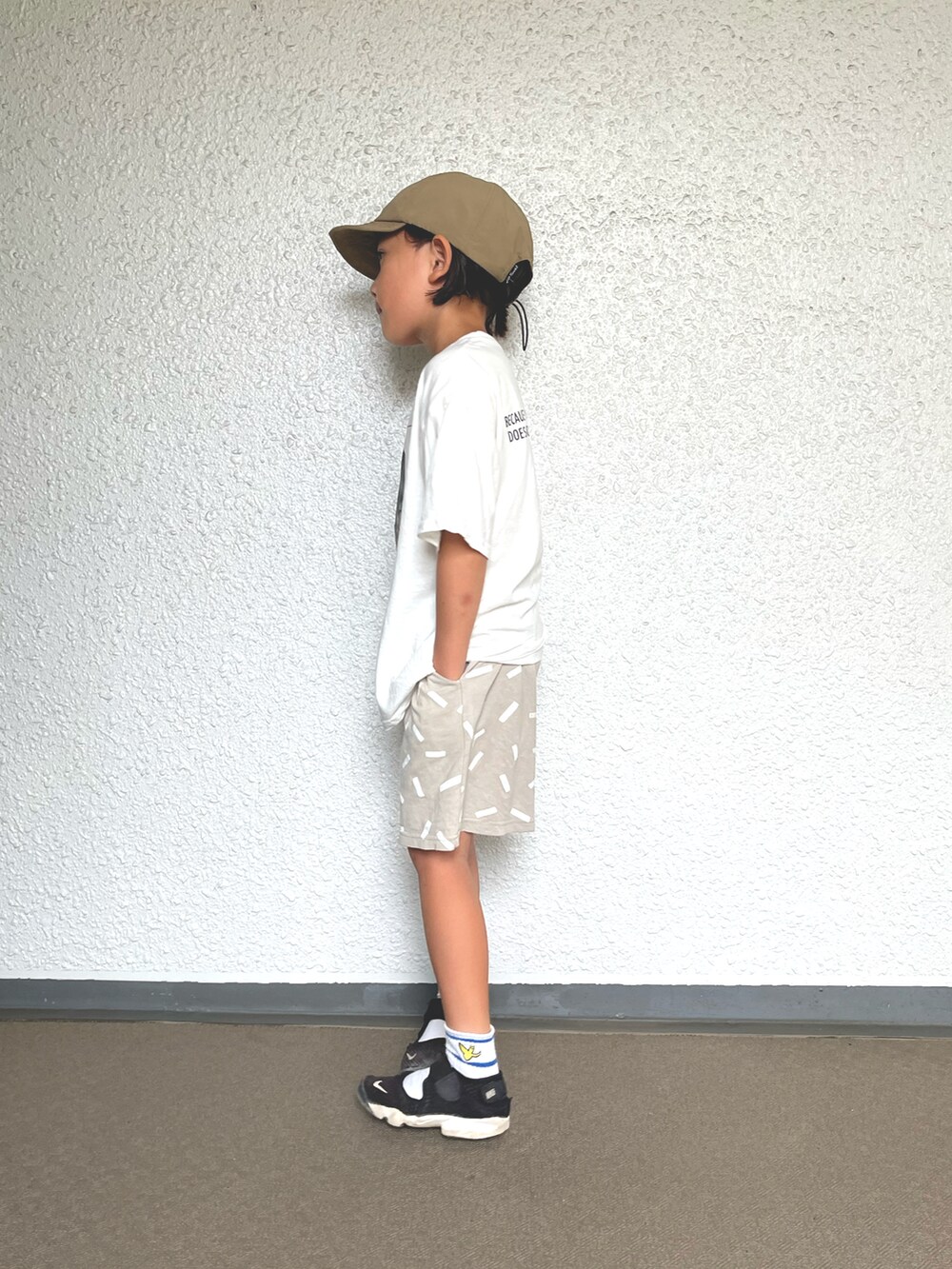 ホワイト系のTシャツ/カットソー、グレー系のその他パンツ、ブラック系のスニーカーを着用したキッズの秋コーディネートの2枚目の写真