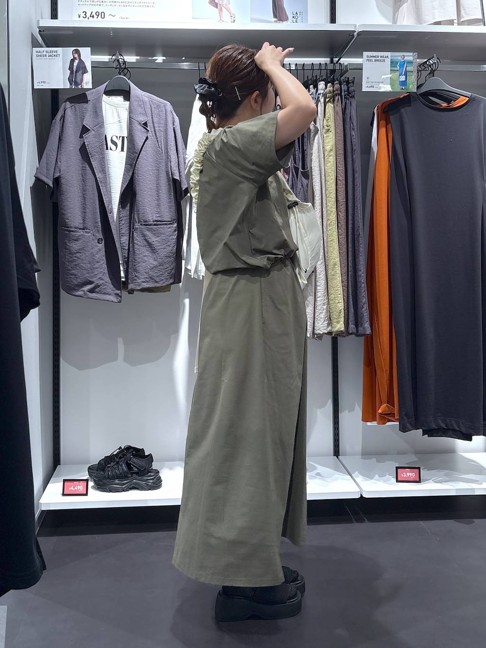 ホワイト系のショルダーバッグ、ブラック系のサンダル、グリーン系のTシャツ/カットソーを着用したレディースの夏コーディネートの3枚目の写真