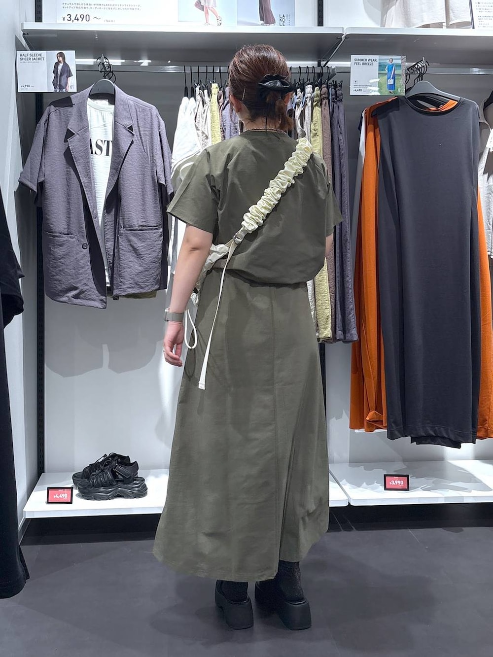 ホワイト系のショルダーバッグ、ブラック系のサンダル、グリーン系のTシャツ/カットソーを着用したレディースの夏コーディネートの2枚目の写真