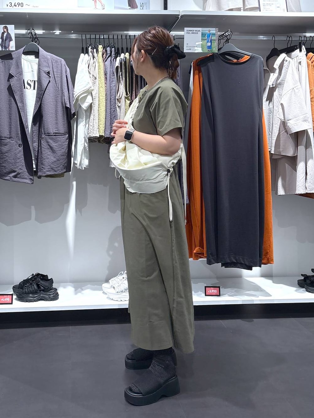 ホワイト系のショルダーバッグ、ブラック系のサンダル、グリーン系のTシャツ/カットソーを着用したレディースの夏コーディネートの4枚目の写真