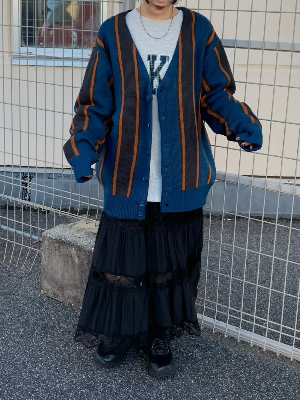 ベージュ系のスウェット、ブラック系のスカート、ブラック系のスニーカーを着用したレディースの秋コーディネートの2枚目の写真