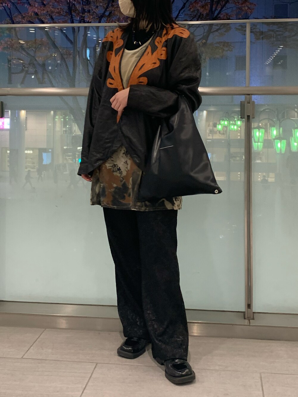 ブラウン系のトップス、ブラック系のハンドバッグ、ブラック系のニット/セーターを着用したレディースの秋コーディネートの2枚目の写真