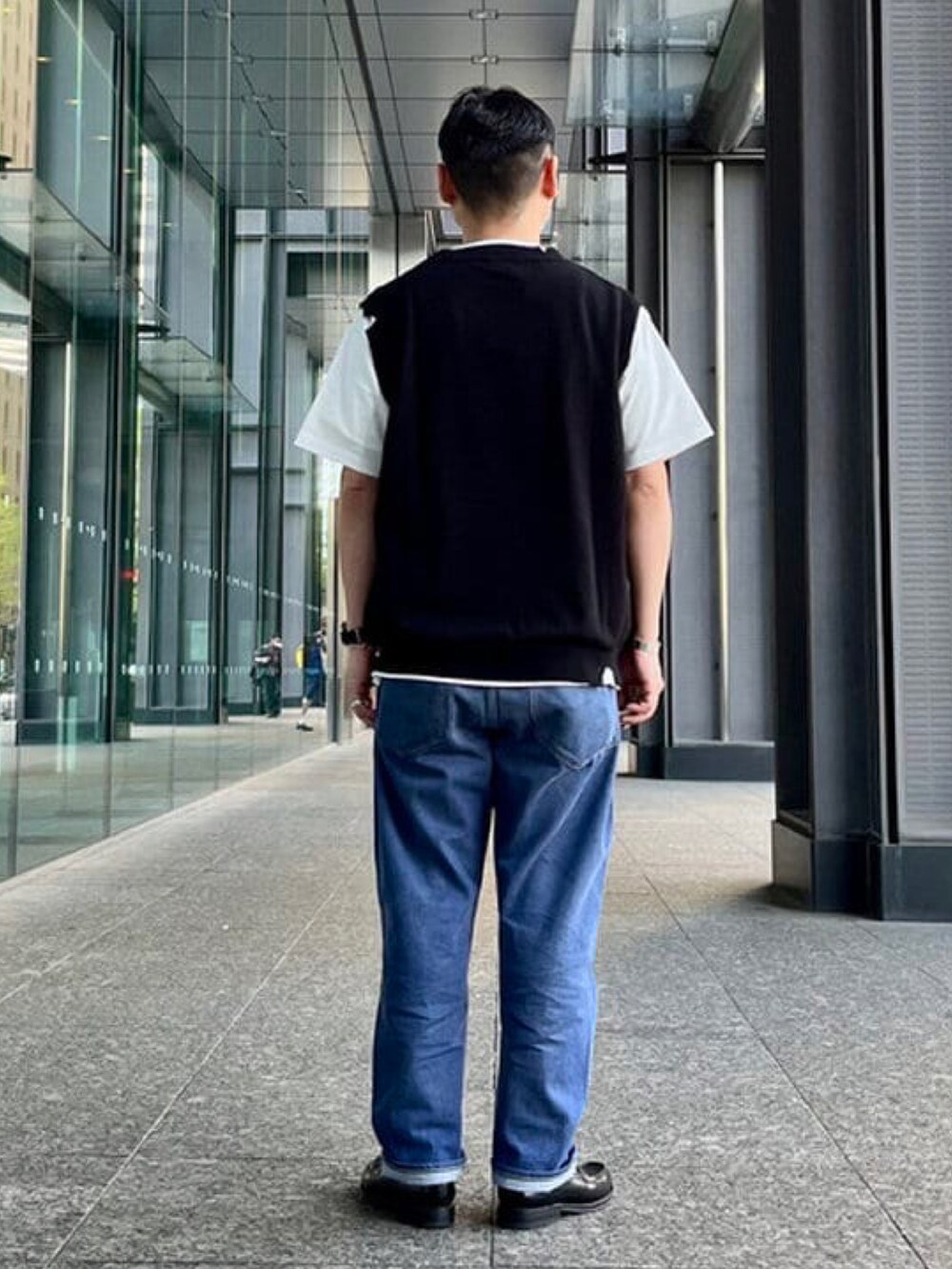 ブラック系のベスト、ホワイト系のTシャツ/カットソー、シルバー系のブレスレットを着用したメンズの春コーディネートの3枚目の写真