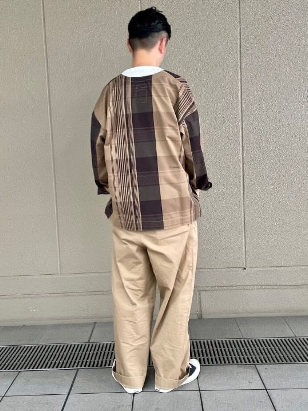 ブラウン系のブルゾン、ホワイト系のTシャツ/カットソーを着用したメンズの秋コーディネートの2枚目の写真