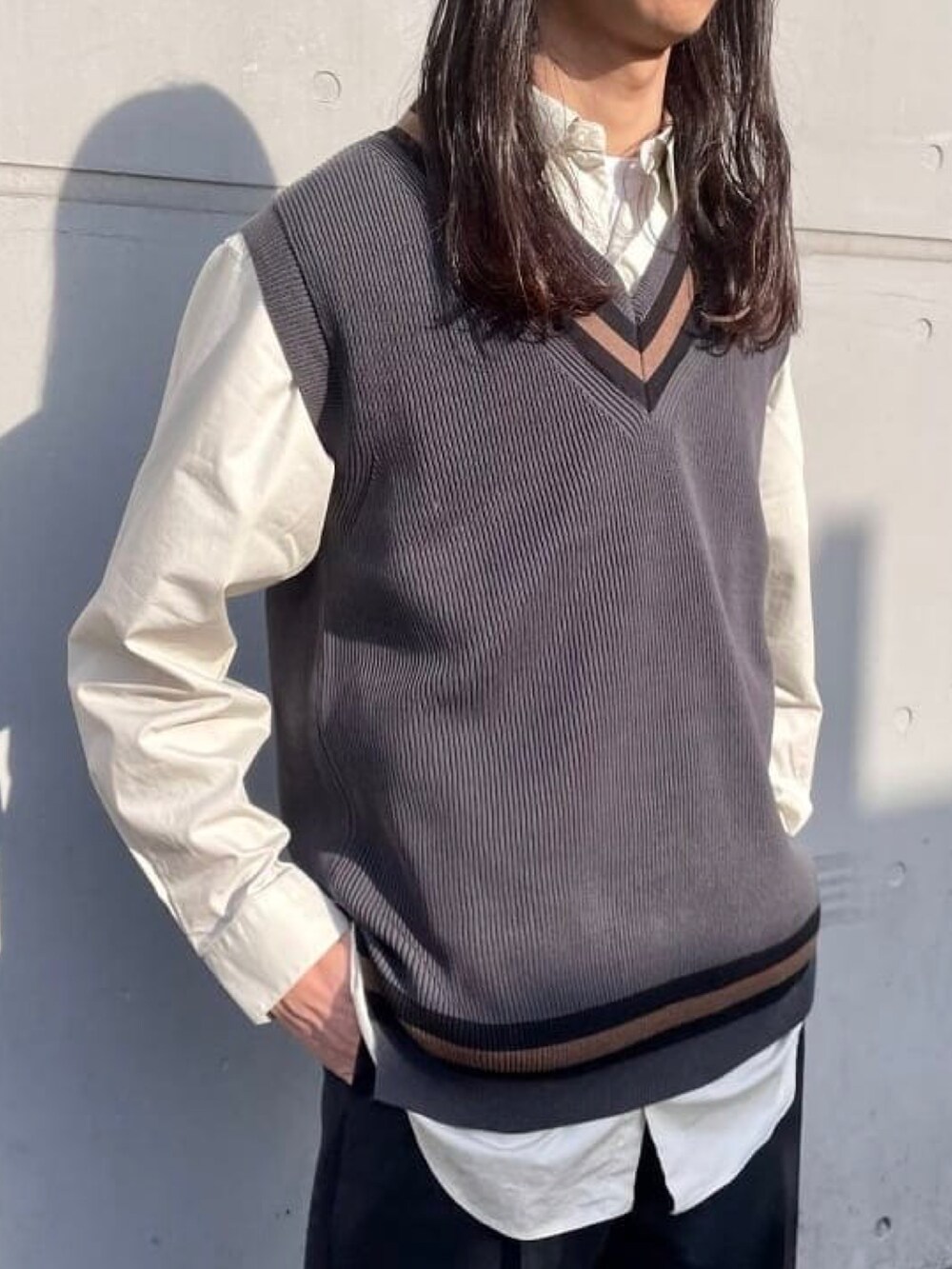 グレー系のベスト、ベージュ系のシャツ/ブラウス、ブルー系のスラックスを着用したメンズの春コーディネートの2枚目の写真