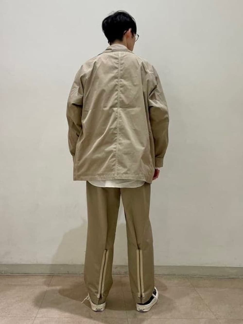 ベージュ系のカバーオール、ベージュ系のスラックス、ホワイト系のシャツ/ブラウスを着用したメンズの春コーディネートの3枚目の写真