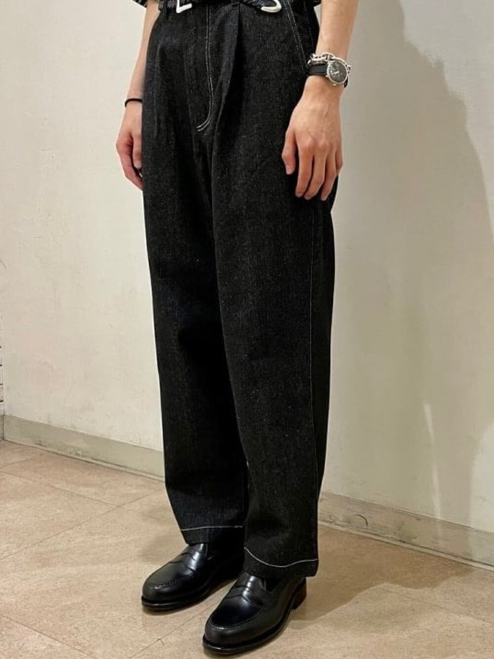 グリーン系のTシャツ/カットソー、ブラック系のデニムパンツ、ブラック系のローファーを着用したメンズの夏コーディネートの3枚目の写真