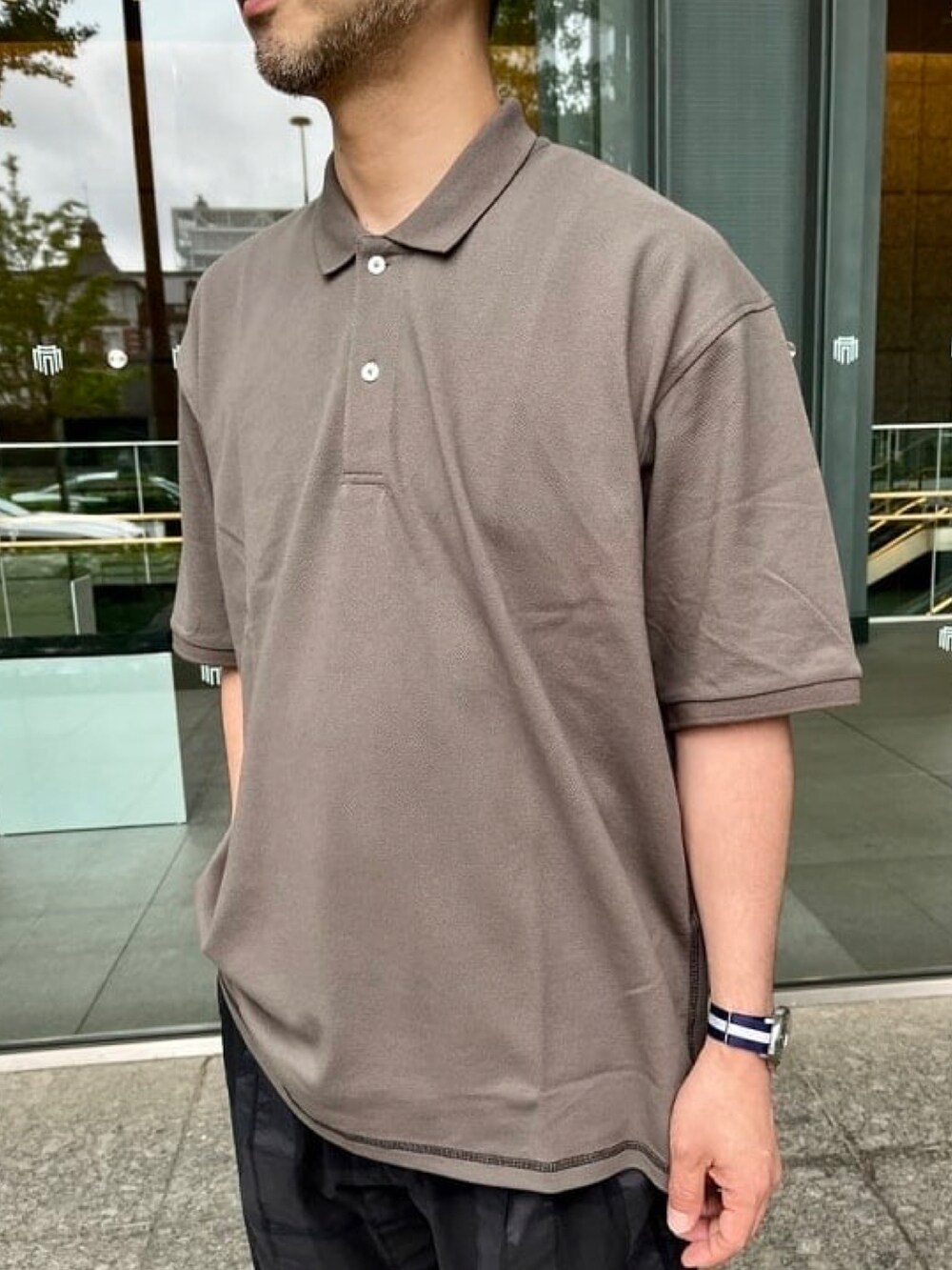 グレー系のポロシャツ、グレー系のその他パンツ、その他のサンダルを着用したメンズの春コーディネートの4枚目の写真