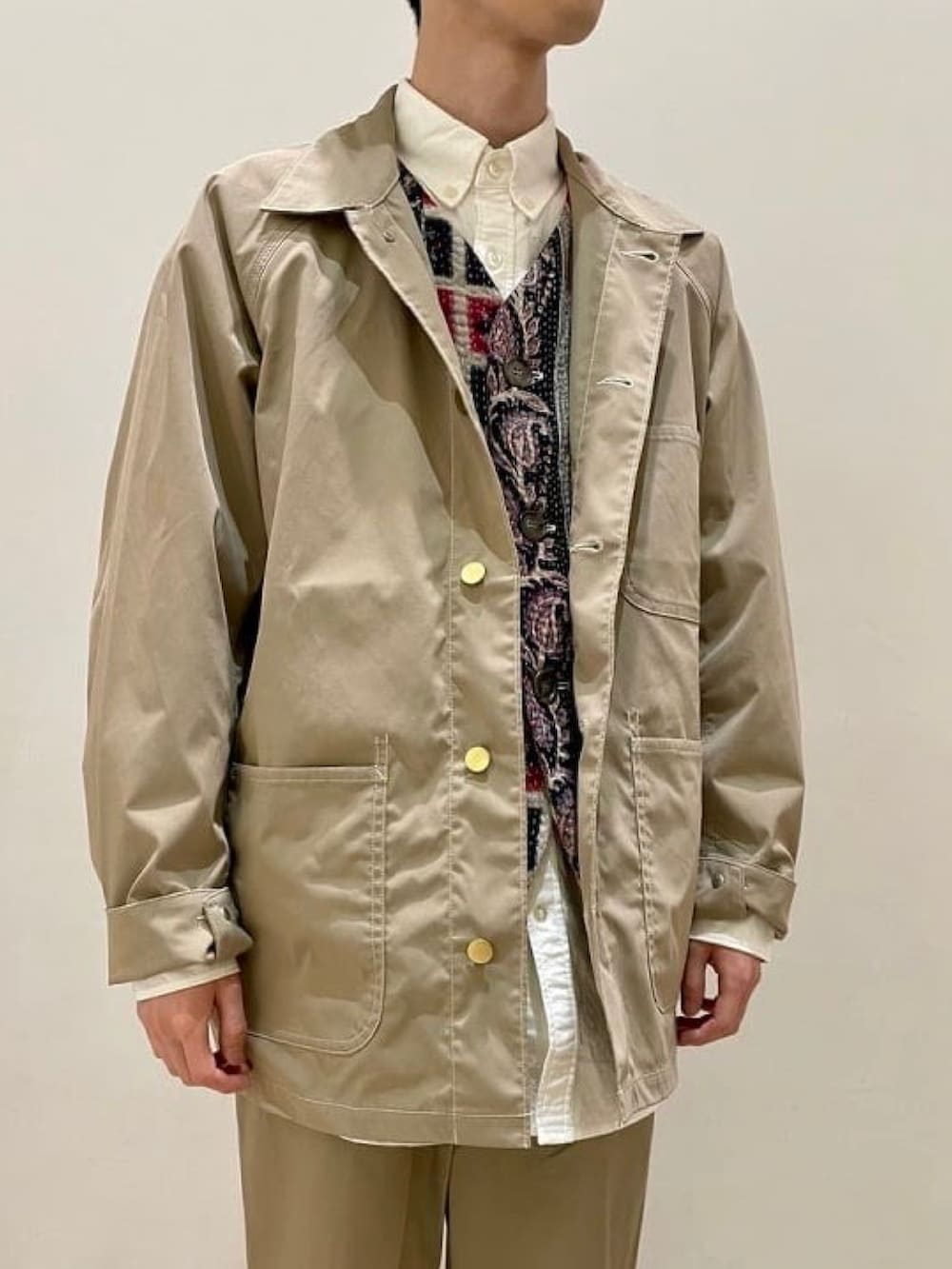 ベージュ系のカバーオール、ベージュ系のスラックス、ホワイト系のシャツ/ブラウスを着用したメンズの春コーディネートの4枚目の写真