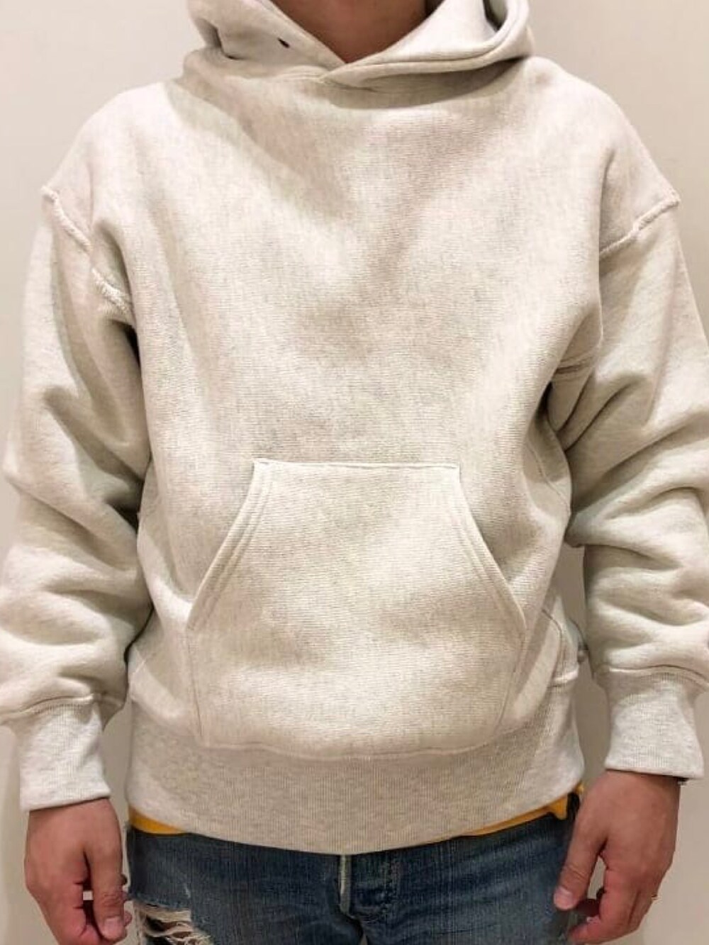 グリーン系のベスト、ホワイト系のパーカーを着用したメンズの秋コーディネートの3枚目の写真