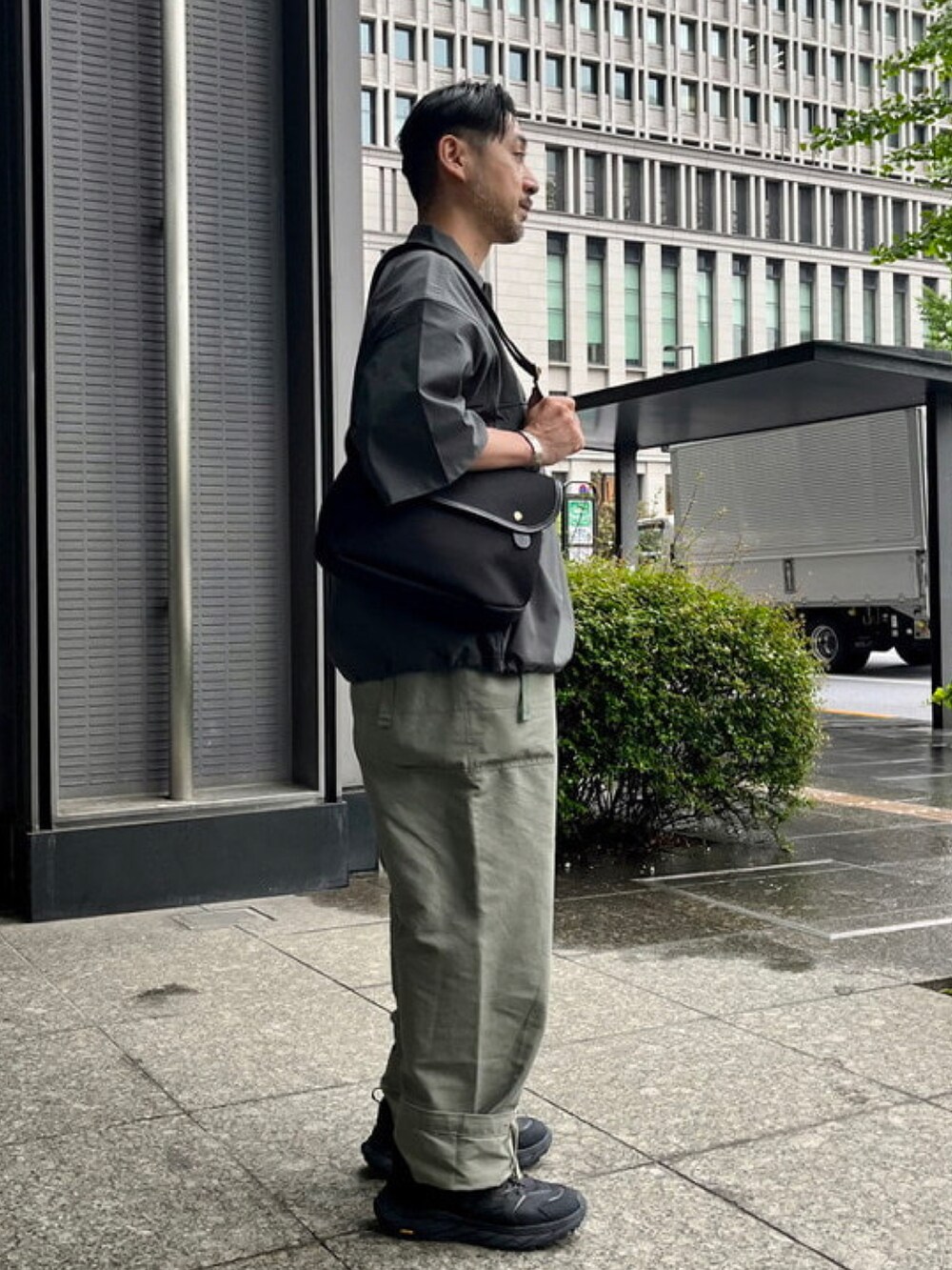 グレー系のシャツ/ブラウス、ブラック系のショルダーバッグを着用したメンズの春コーディネートの2枚目の写真