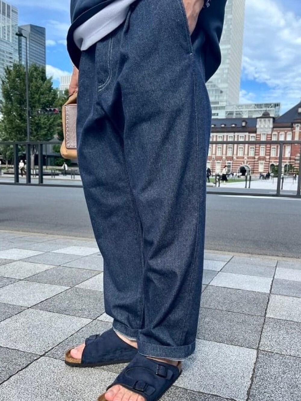 ブルー系のTシャツ/カットソー、ブルー系のデニムパンツ、ブラウン系のハンドバッグを着用したメンズの夏コーディネートの5枚目の写真