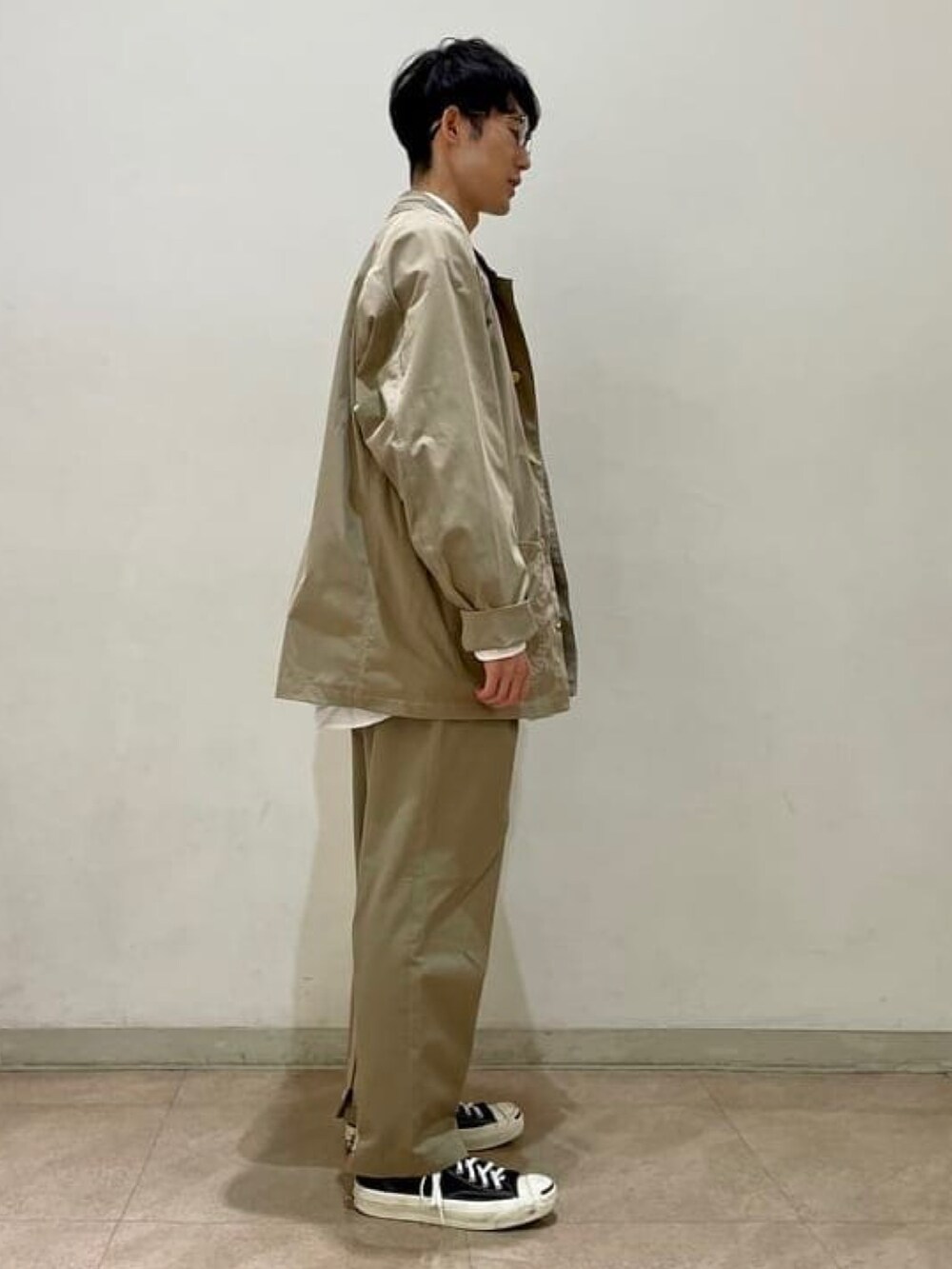 ベージュ系のカバーオール、ベージュ系のスラックス、ホワイト系のシャツ/ブラウスを着用したメンズの春コーディネートの2枚目の写真