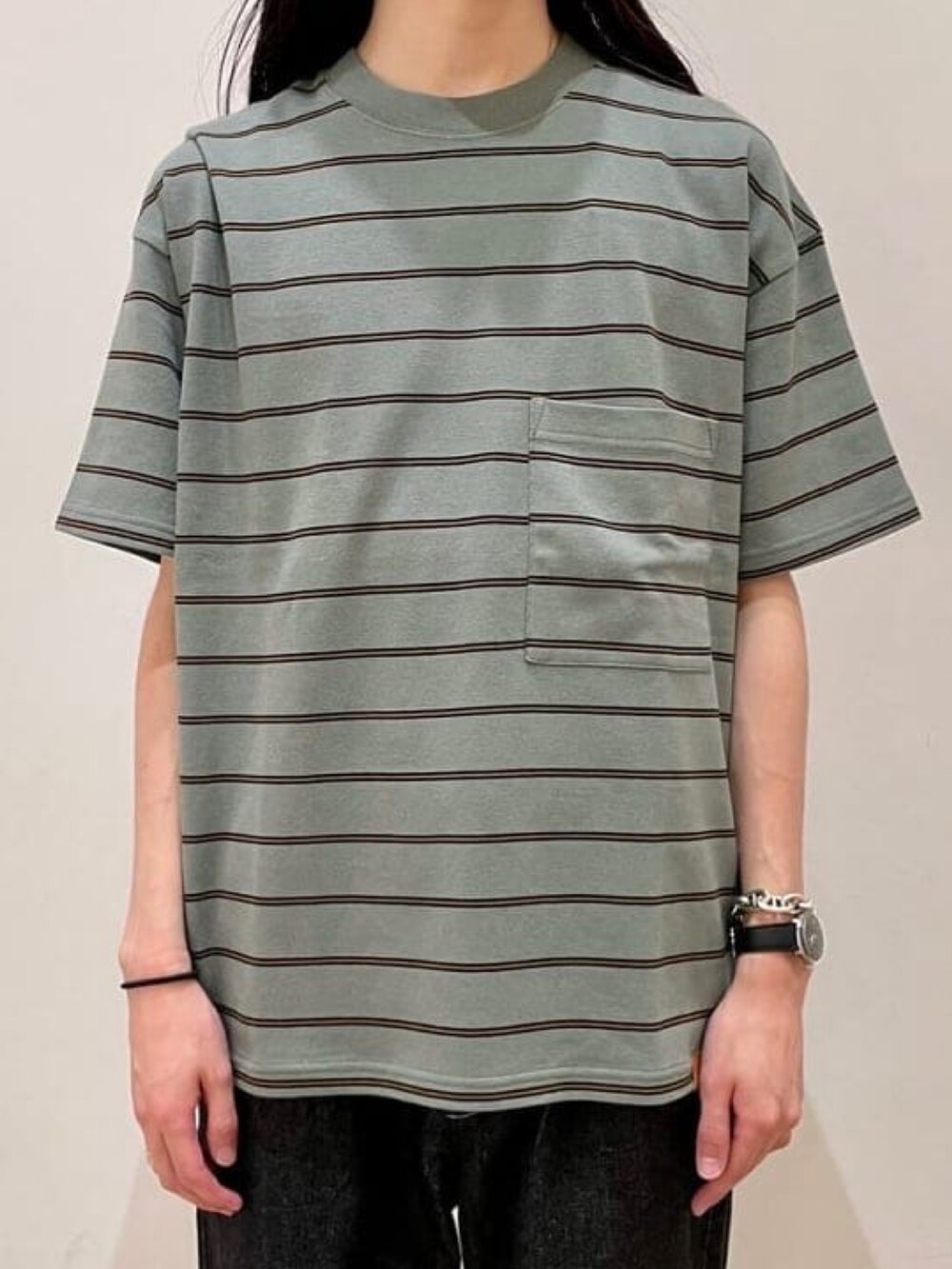 グリーン系のTシャツ/カットソー、ブラック系のデニムパンツ、ブラック系のローファーを着用したメンズの夏コーディネートの2枚目の写真