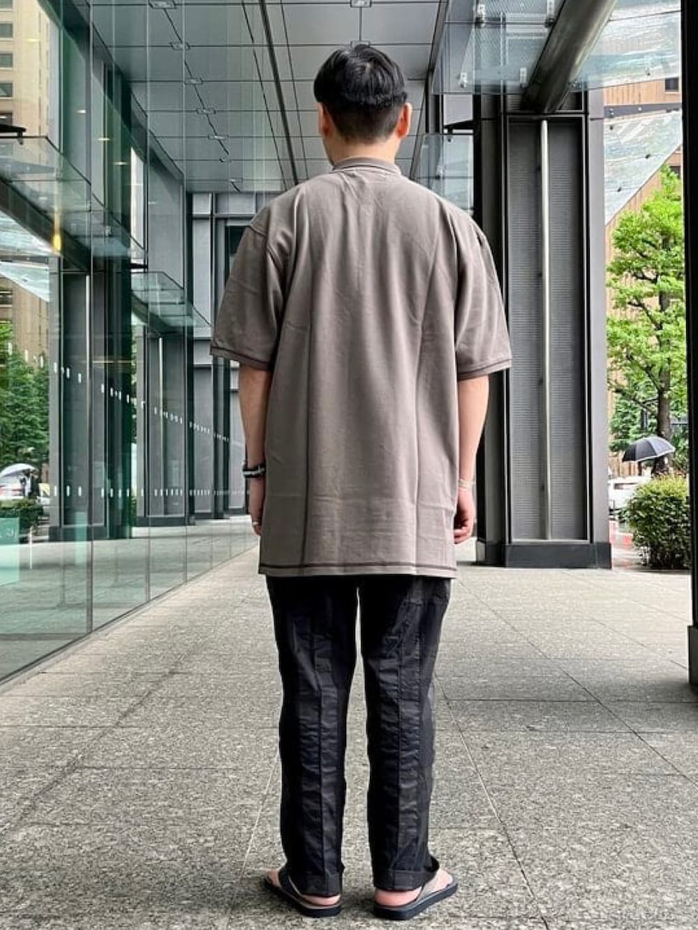 グレー系のポロシャツ、グレー系のその他パンツ、その他のサンダルを着用したメンズの春コーディネートの3枚目の写真