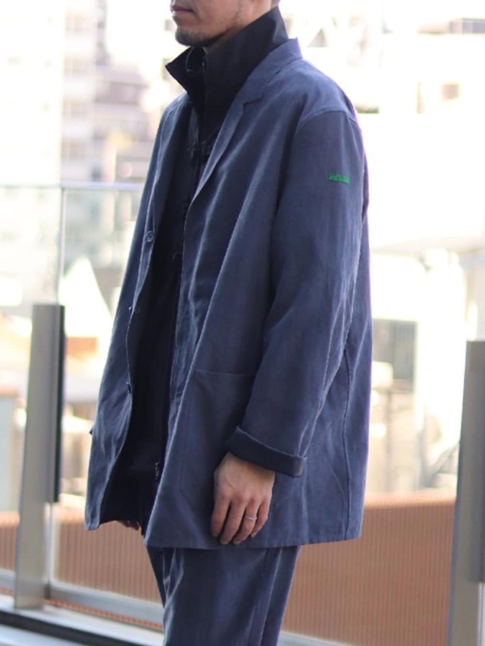 ブルー系のテーラードジャケット、ブルー系のその他パンツ、ブラック系のブルゾンを着用したメンズの冬コーディネートの2枚目の写真