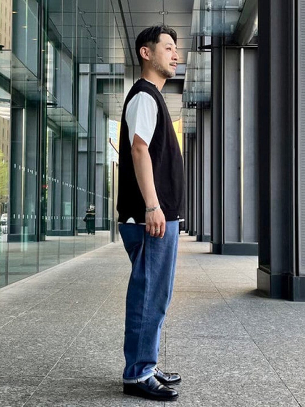 ブラック系のベスト、ホワイト系のTシャツ/カットソー、シルバー系のブレスレットを着用したメンズの春コーディネートの2枚目の写真