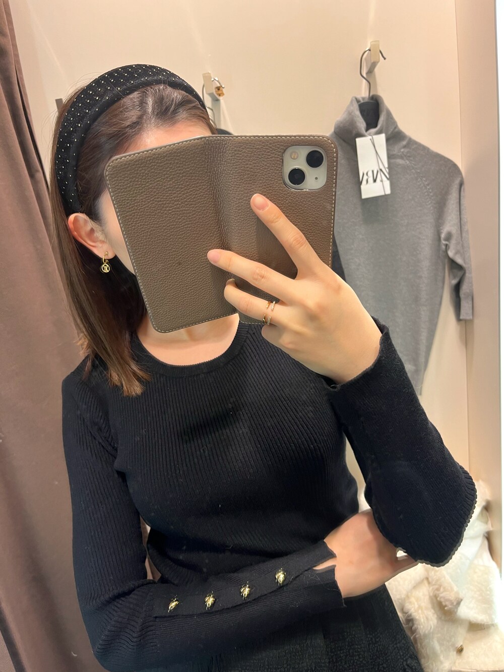 ブラック系のニット/セーター、ホワイト系のノーカラージャケット、ブラック系のスカートを着用したレディースの冬コーディネートの2枚目の写真