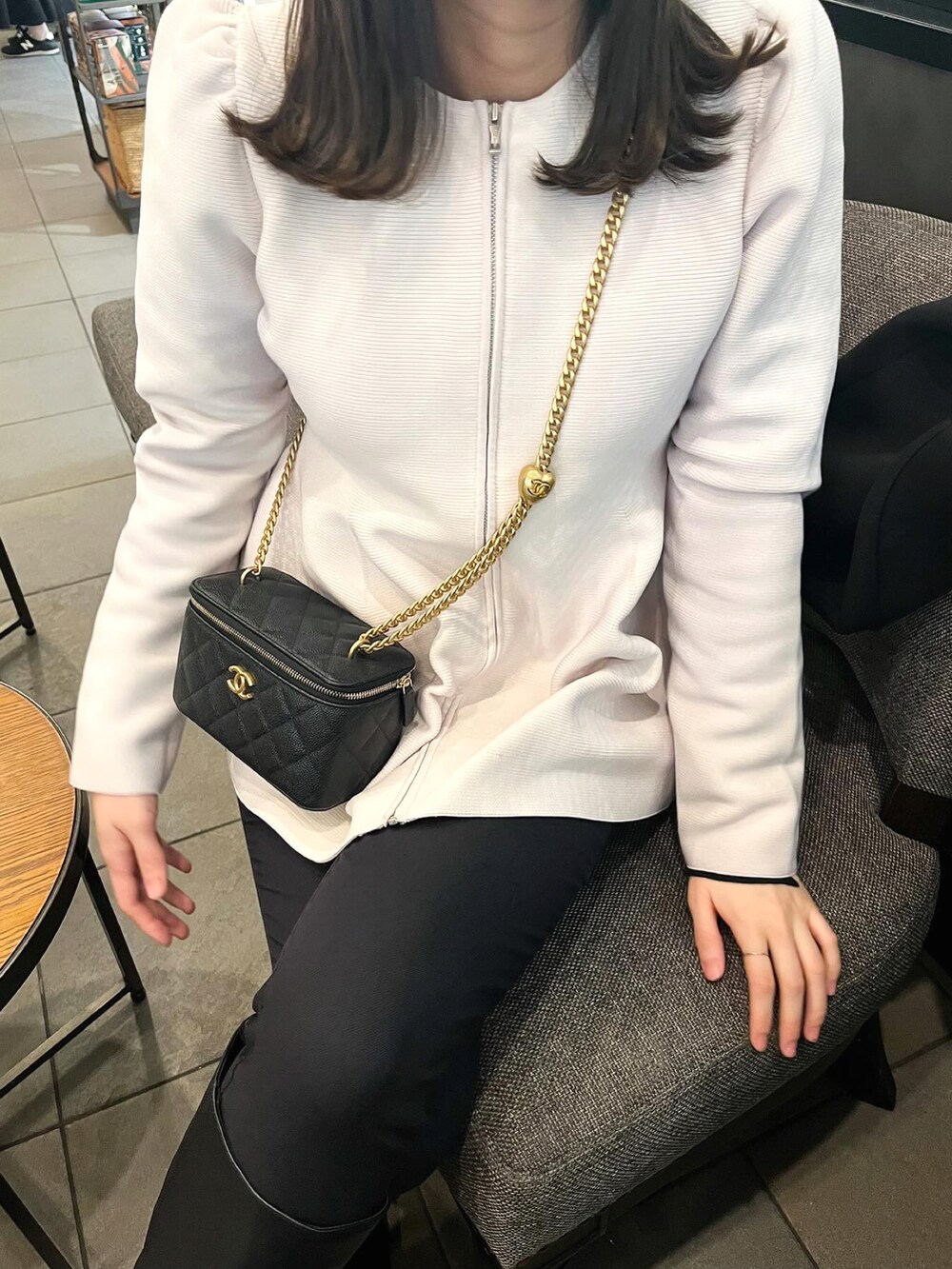 ピンク系のカーディガン/ボレロ、ブラック系のパンツ、ブラック系のショルダーバッグを着用したレディースの春コーディネートの2枚目の写真