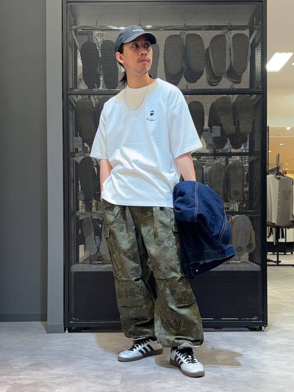 ブルー系のデニムジャケット、グリーン系のカーゴパンツ、ホワイト系のTシャツ/カットソーを着用したメンズの春コーディネートの4枚目の写真