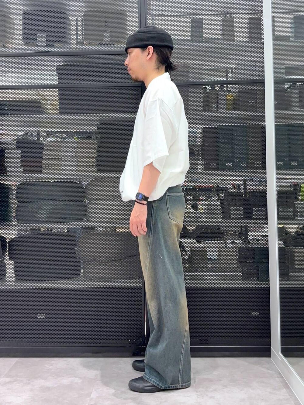 グレー系のデニムパンツ、ホワイト系のシャツ/ブラウス、ブラック系のニットキャップ/ビーニーを着用したメンズの夏コーディネートの2枚目の写真