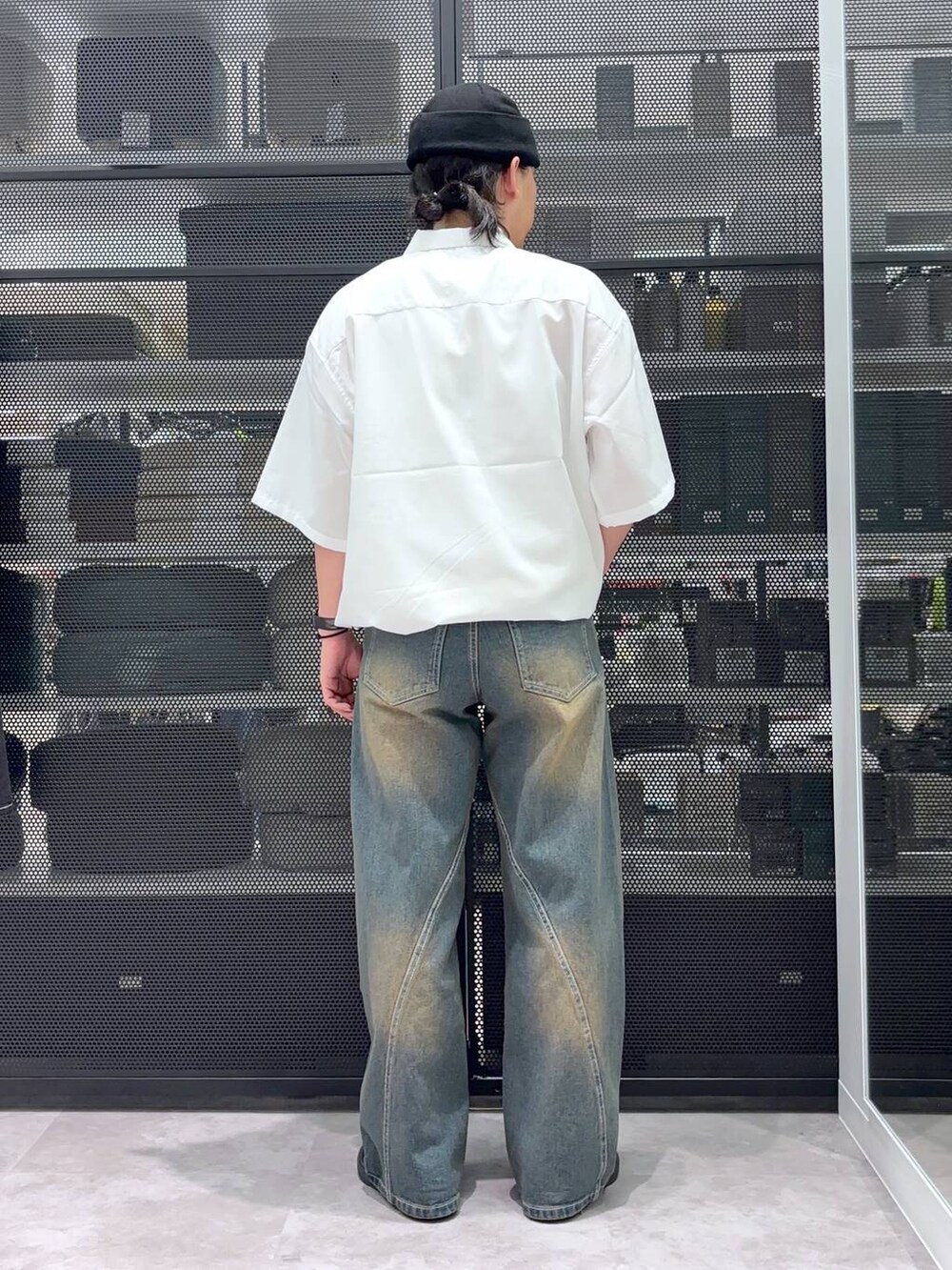 グレー系のデニムパンツ、ホワイト系のシャツ/ブラウス、ブラック系のニットキャップ/ビーニーを着用したメンズの夏コーディネートの3枚目の写真